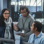 homem explicando algo em tablet para colegas de equipe