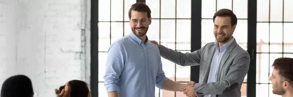 líder de equipe apertando a mão de colega em reunião