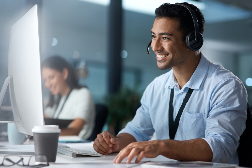 Homem jovem sorrindo no trabalho. Inteligência emocional dicas.